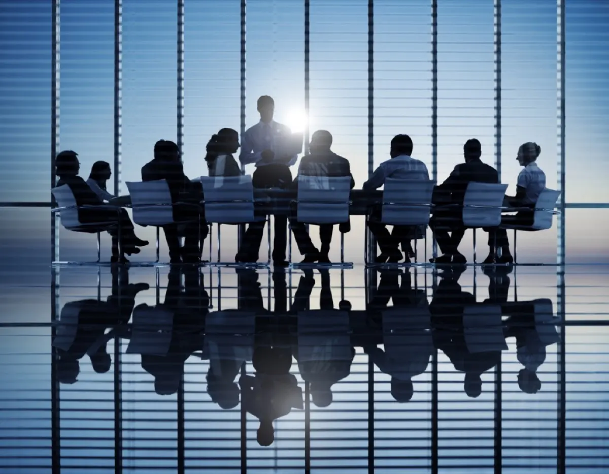 Equipe reunida em volta de uma mesa, conversando sobre o trabalho